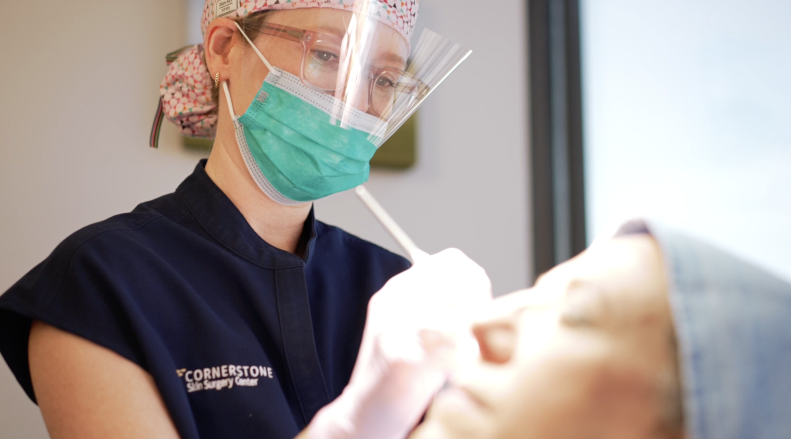 A dermatologist is examining a patient's skin during a skin cancer screening.